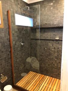 a shower with a wooden bench in a bathroom at Lodge Crux in Pichilemu
