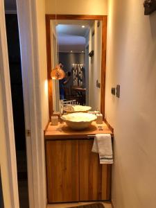 een badkamer met een wastafel en een spiegel bij Lodge Crux in Pichilemu