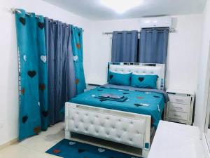 a bedroom with a bed with blue curtains at Casa en Baní cerca de playa los almendros in Baní