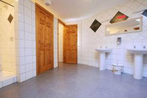 baño con 2 lavabos, bañera y puertas de madera en Fáilte Lodging Kenmare-ROOM ONLY, en Kenmare