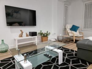 - un salon avec une télévision et une table basse en verre dans l'établissement Casa Roman LUX, à León