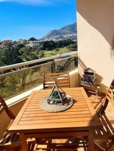 een houten tafel en stoelen op een balkon bij Soleado apartamento Golf y a 900 m de la playa in Benalmádena