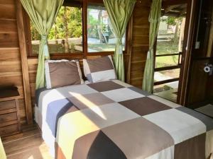 um quarto com uma cama com um cobertor xadrez em L'Oasis Don Juan em Don Juan