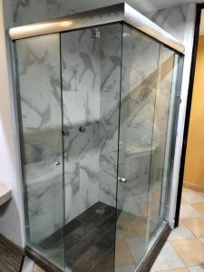 a glass shower in a room with marble at Hotel Florencia in Mexico City