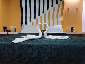 een bed met twee handdoeken in de vorm van een hart bij Hotel Florencia in Mexico-Stad