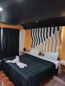 a bedroom with a bed with two white shoes on it at Hotel Florencia in Mexico City