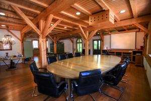 einen Konferenzraum mit einem großen Holztisch und Stühlen in der Unterkunft Gästehaus Craintaler Mühle B&B in Creglingen