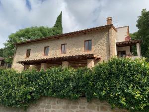 a stone house with a hedge in front of it at Parulia Country House in Arezzo