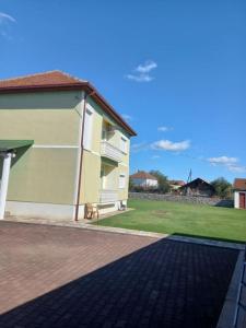 a house with a brick walkway next to a yard at Vila Arapovi - Bosilovo in Strumica