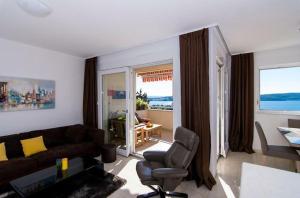 uma sala de estar com um sofá e uma cadeira em Sunny place with sea view em Trogir