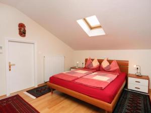 Schlafzimmer mit einem roten Bett und einem Dachfenster in der Unterkunft Apartments Villa Kapelica in Barbat na Rabu