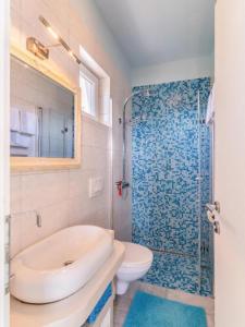 ein Badezimmer mit Waschbecken, Toilette und Dusche in der Unterkunft Apartments Villa Kapelica in Barbat na Rabu