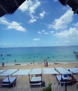 Ein Strand mit einem Haufen Leute im Wasser. in der Unterkunft NENA BEACH CLUB & HOTEL in Barú