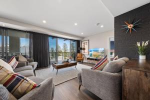 a living room with two couches and a fireplace at Ocean View Spacious Luxury 3 Bedroom, Pool, Central, Walk everywhere 6PM CHECKOUT in The Entrance