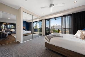 a bedroom with a large bed and glass walls at Ocean View Spacious Luxury 3 Bedroom, Pool, Central, Walk everywhere 6PM CHECKOUT in The Entrance