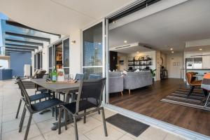 a dining room and living room with a table and chairs at Ocean View Spacious Luxury 3 Bedroom, Pool, Central, Walk everywhere 6PM CHECKOUT in The Entrance +25 photos