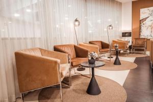 a waiting room with leather chairs and tables at Vitoria Hotel in Fátima