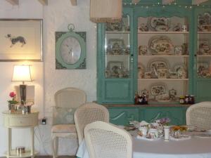 a room with a table with chairs and a clock at Yr Hen Felin - The Old Mill B&B in Morfa Nefyn
