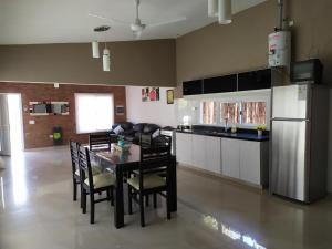 Una cocina con mesa y sillas y un refrigerador. en Loft las rosas, en Villa María
