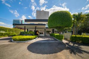 a building with bushes and trees in front of it at KC Hotel San Jose in San José