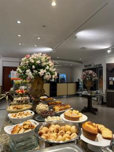 un buffet de repostería y postres en una mesa en Hotel Capital Das Pedras, en Teófilo Otoni