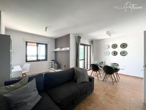 un salon avec un canapé noir et une table dans l'établissement Villa Patricia, à Corralejo