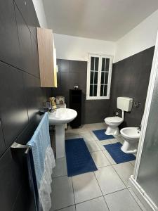 a bathroom with two toilets and a sink and a shower at Casa Antonella in Pozzallo