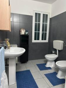 a bathroom with a white sink and a toilet at Casa Antonella in Pozzallo