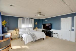 sypialnia z łóżkiem i telewizorem oraz niebieskimi ścianami w obiekcie Spacious Lakefront House with Backyard Fire Pit w mieście Monroe
