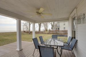 a porch with a ceiling fan and a table and chairs at Spacious Lakefront House with Backyard Fire Pit in Monroe
