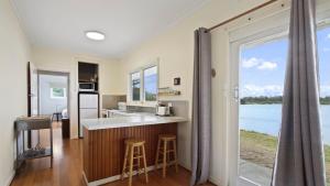 una cocina con un bar con vistas al agua en Jetty Road on the Beach, en Lakes Entrance