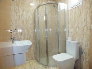 a bathroom with a shower and a toilet and a sink at Hotel El Medina in Nouadhibou