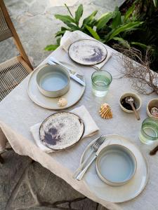 a table with plates and utensils on it at Tallowwood House Luxury Bed & Breakfast in Port Macquarie