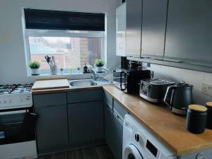 a kitchen with a sink and a stove top oven at Hotel 3H in Stafford