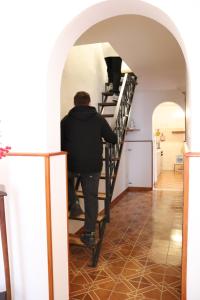 un hombre subiendo las escaleras en una casa en Casa Mafalda en Aradeo
