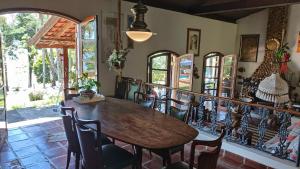a dining room with a wooden table and chairs at Casa de Campo em Ibiúna de frente para represa in Ibiúna