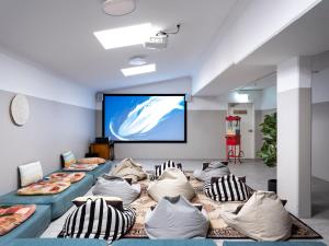 a room with couches and a projection screen at Stoke Beach House in Sydney