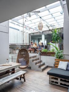 a lobby with tables and chairs and a staircase at Stoke Beach House in Sydney