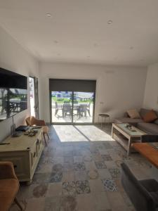 un soggiorno con un divano e un tavolo di Casas Caiado Two Houses with swimming POOL a Faro