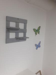 dos mariposas en una pared al lado de un estante en Private room MH102 close to old city, en Cartagena de Indias