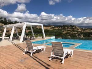 2 sillas sentadas en una terraza junto a una piscina en Hermoso departamento de lujo - Zona Miraflores, en Tarija