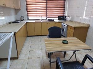 eine Küche mit einem Schreibtisch, einem Tisch und einem Waschbecken in der Unterkunft Cozy Home in Amman