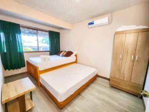 a small room with two beds and a window at Apartamentos La Primavera - Santiago Centro in Santiago