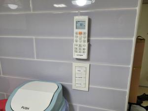 a bathroom with a toilet and a remote control at Yeongtong Family House in Suwon +37 photos
