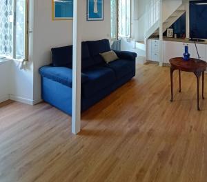 a blue couch in a living room with a wooden floor at Tolli Colosseo Apartment in Rome