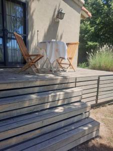 2 Stühle und ein Tisch auf der Veranda eines Hauses in der Unterkunft HABITACION CON PISCINA Y PARQUE en Chacras de Coria in Chacras de Coria
