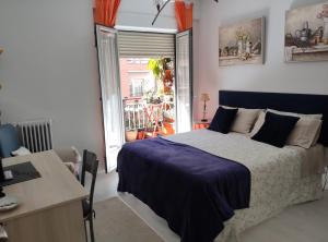 Un dormitorio con una cama y un escritorio y una ventana. en Apartamento Centro Gallarza, en Logroño