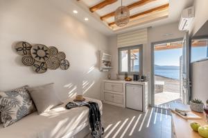 a kitchen and living room with a couch and a table at Porto Dema Luxury Suites in Schinoussa