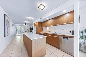 Una cocina grande con gabinetes de madera y encimera. en Whitsunday Wonderview, en Airlie Beach