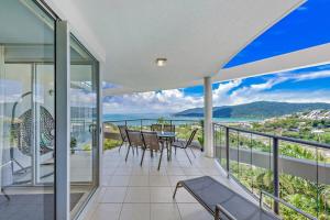 an empty house with a balcony with a table and chairs at Whitsunday Wonderview in Airlie Beach